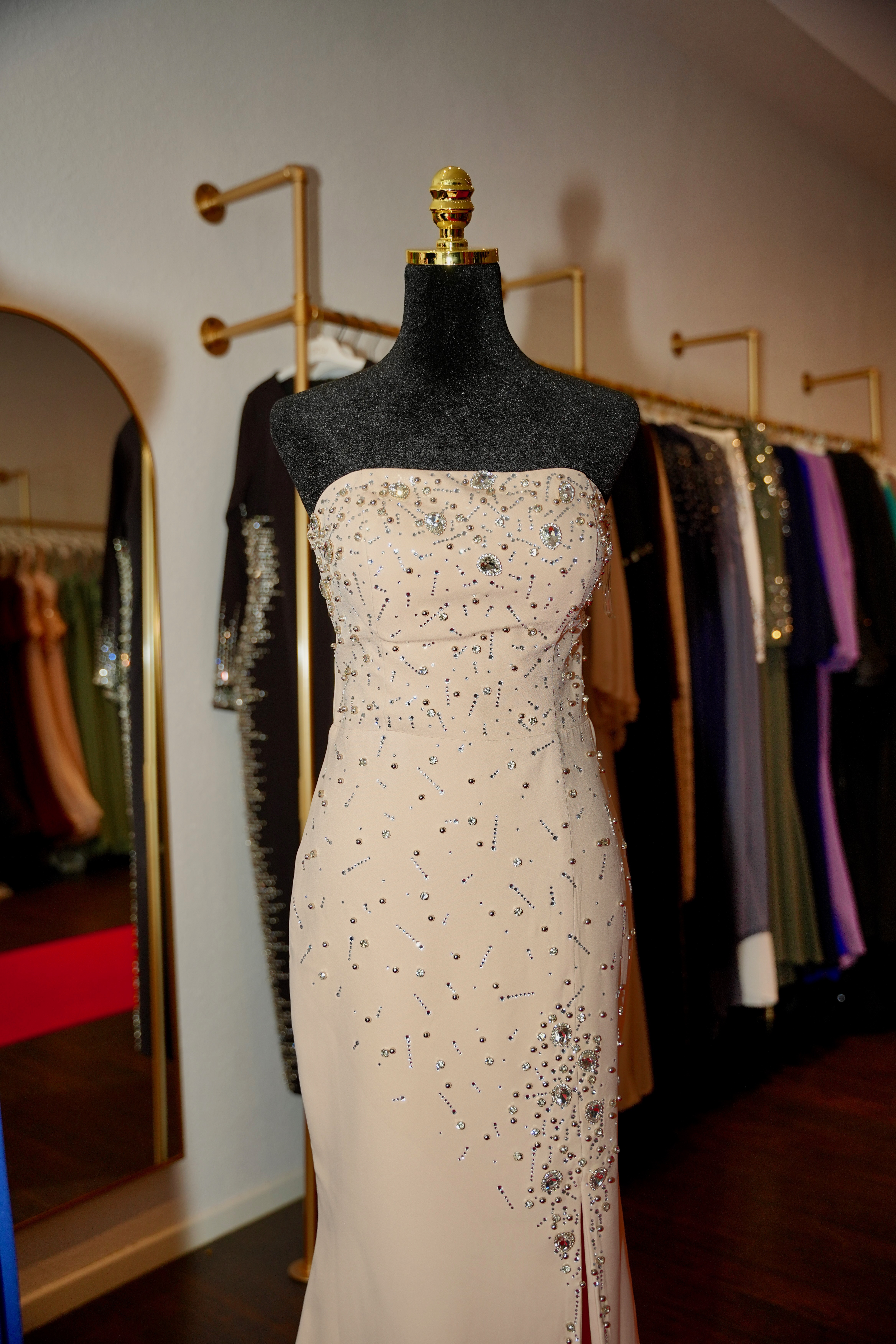 Beiges Abendkleid mit Perlenbesatz auf einer Schneiderpuppe